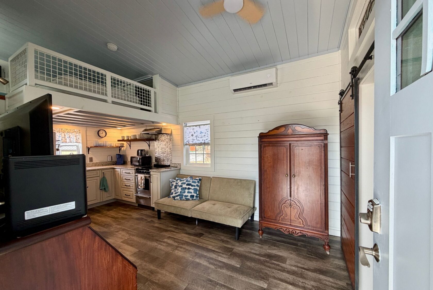 A cozy Empire Lane room features a comfortable couch and a sleek television.