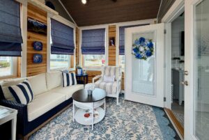 Cozy sunroom at 86 Mount Meadow Lane with navy and white decor, striped furniture, and blue roman shades.