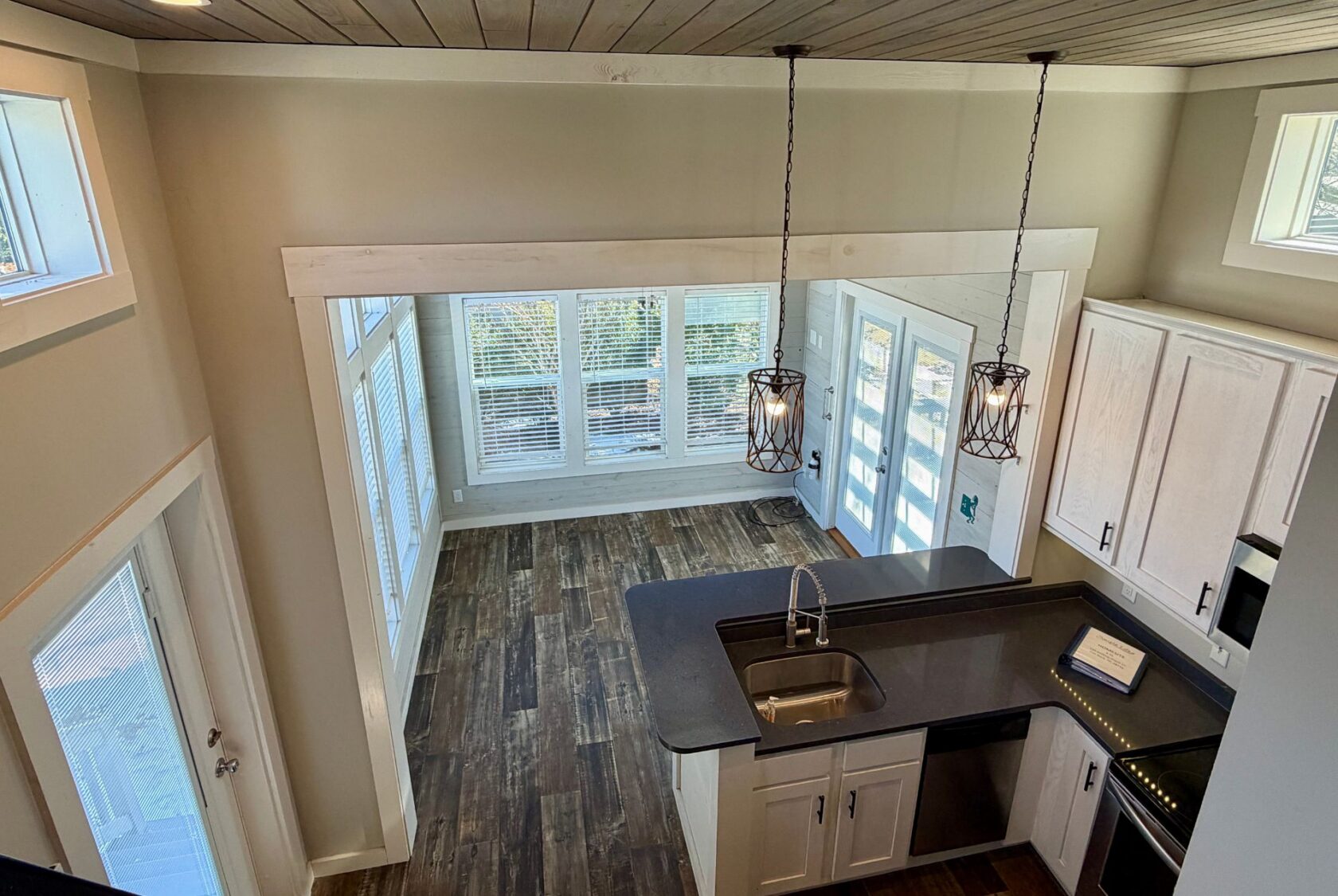 Modern kitchen and dining at 139 Drifting Brook, with wood floors and large windows—perfect real estate opportunity.