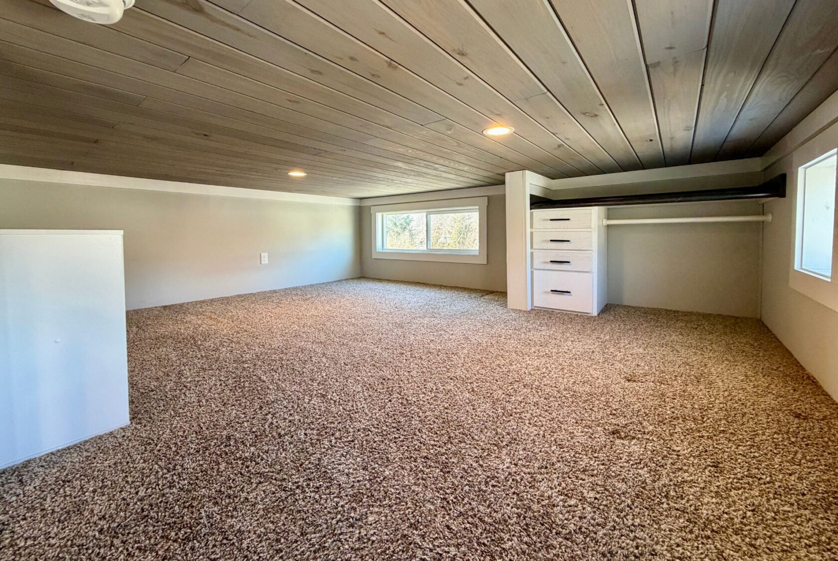 Carpeted loft space with low wood ceiling, windows, white drawers at 139 Drifting Brook Lane real estate.