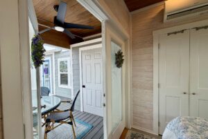 A cozy sunroom at 86 Mount Meadow Lane with a ceiling fan, table, chairs, and a patio door to the outdoors.
