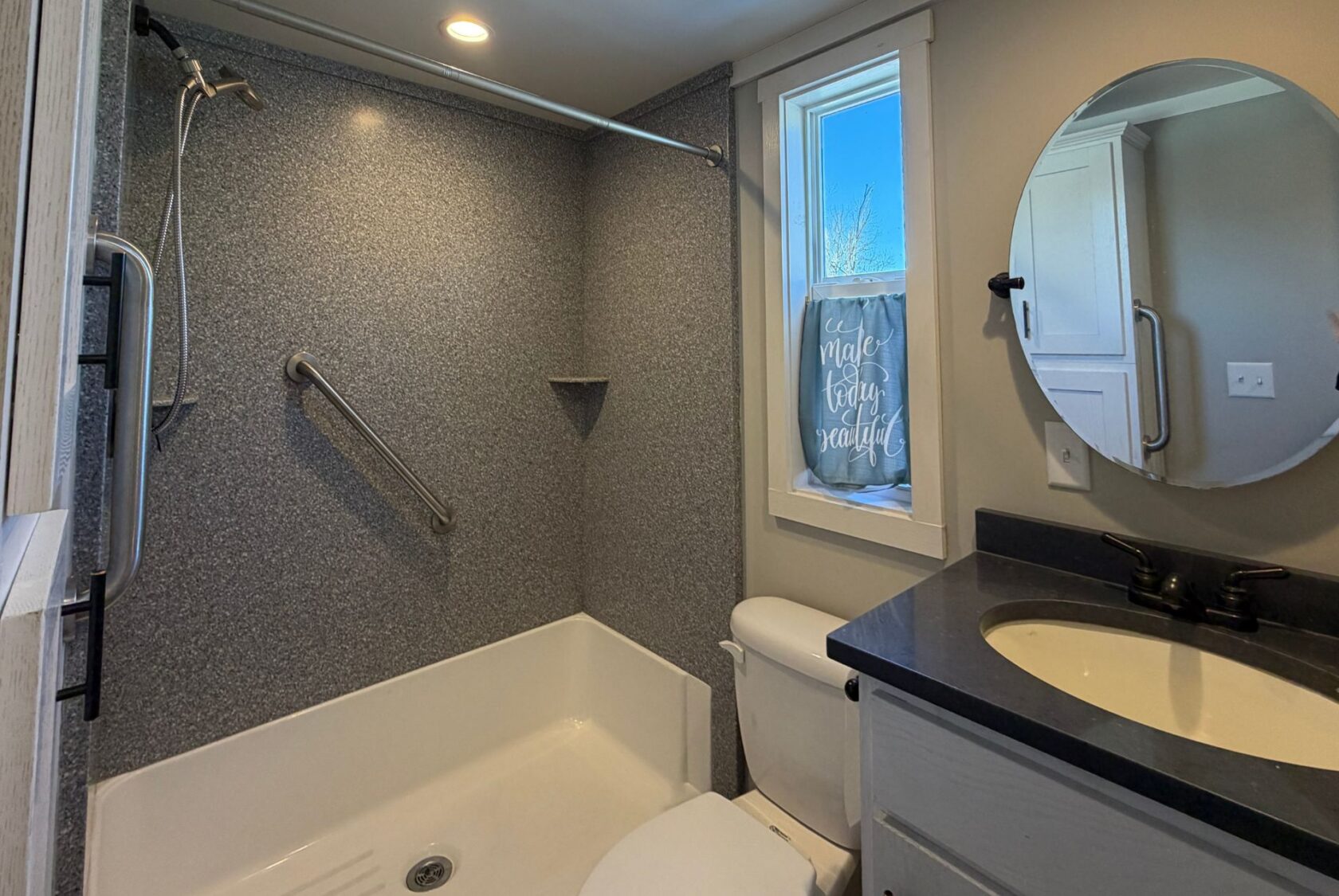 Modern bathroom at 139 Drifting Brook features a bathtub, grab bar, toilet, mirror, and natural light.