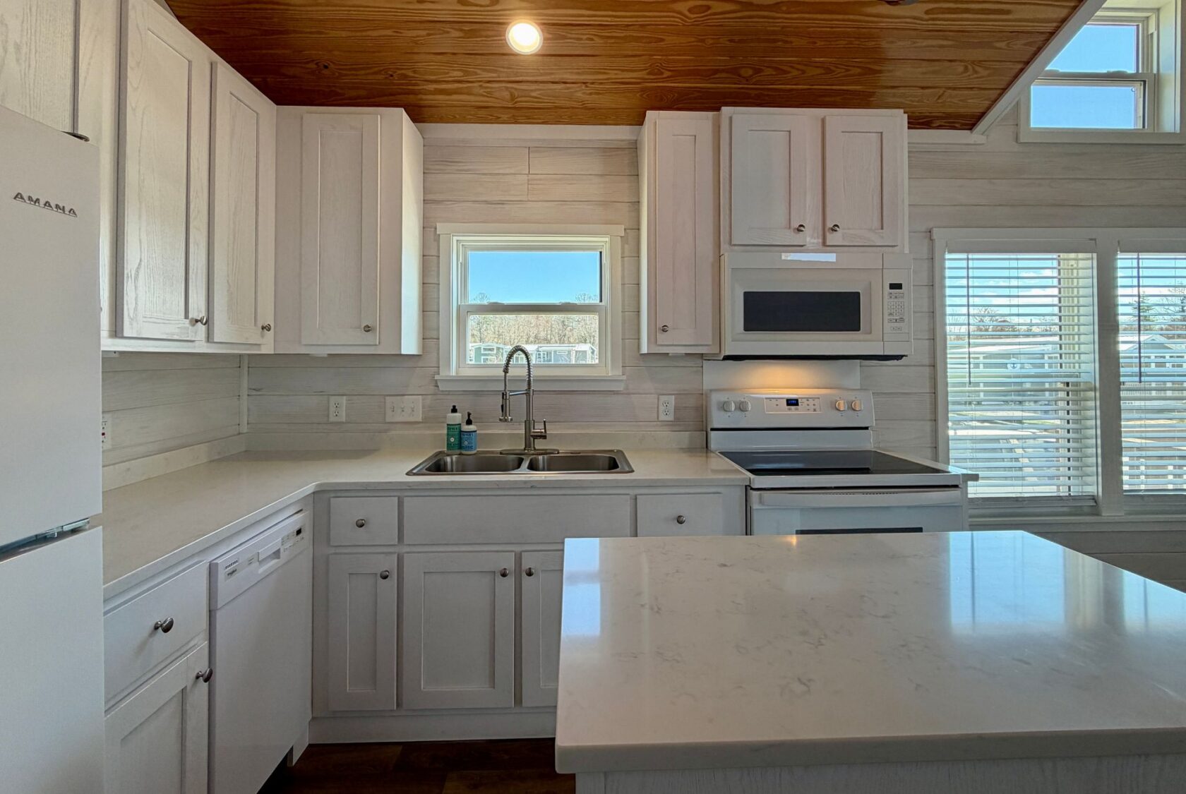 Bright kitchen with white cabinets, marble counters, and an island at 119 Breezy Meadow Lane real estate.