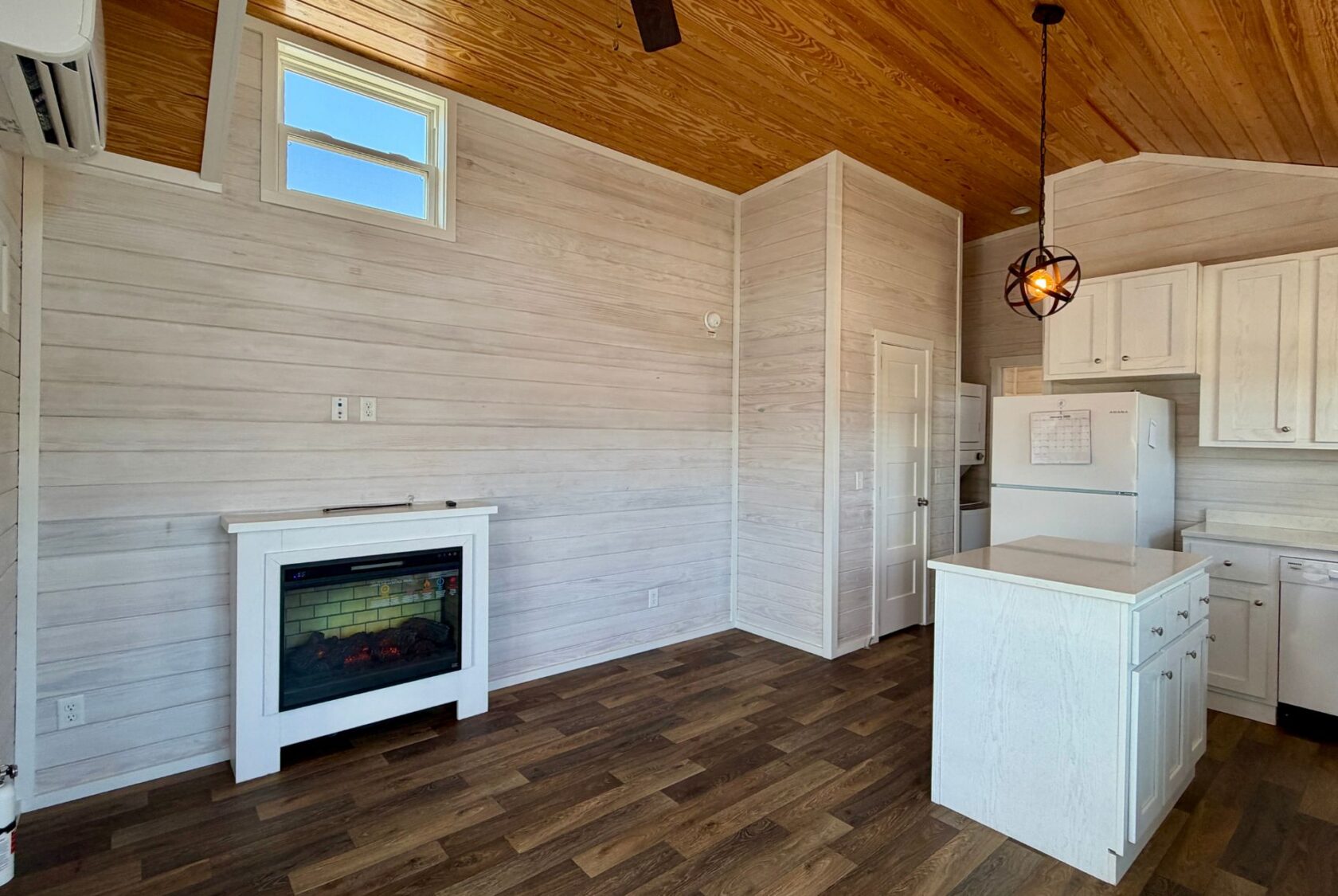 Charming small kitchen at 119 Breezy Meadow with white cabinets, wood accents, and an electric fireplace.