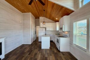 Modern kitchen at 119 Breezy Meadow Lane with white cabinets, wood ceiling, island, and wood-style flooring.
