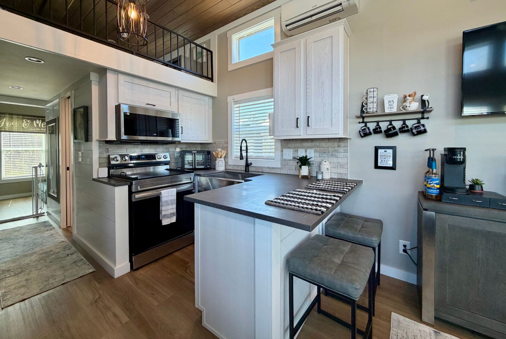 Modern kitchen on Mount Meadow Lane with gray cabinets, stainless steel appliances, breakfast bar, and coffee station.