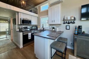 Modern kitchen on Mount Meadow Lane with gray cabinets, stainless steel appliances, breakfast bar, and coffee station.