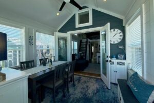 Bright dining area with dark wood table, blue accents, and open doors at 67 Mount Meadow Lane leading to a cozy living space.