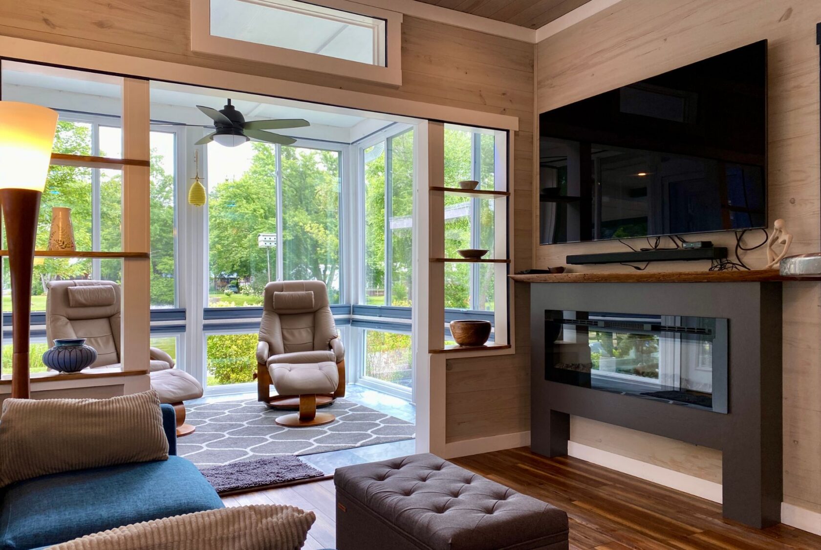 Modern living room on Just Wandering Lane with large windows, two armchairs, and a garden view.