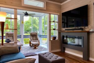Modern living room on Just Wandering Lane with large windows, two armchairs, and a garden view.