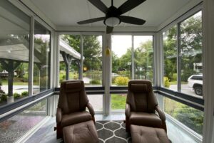 Two brown recliners face large windows with pond views in a bright sunroom on Just Wandering Lane.