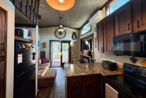 Cozy kitchen and living area at 31 Rest Awhile Lane with dark wood cabinets and sunlight—your perfect vacation rental.