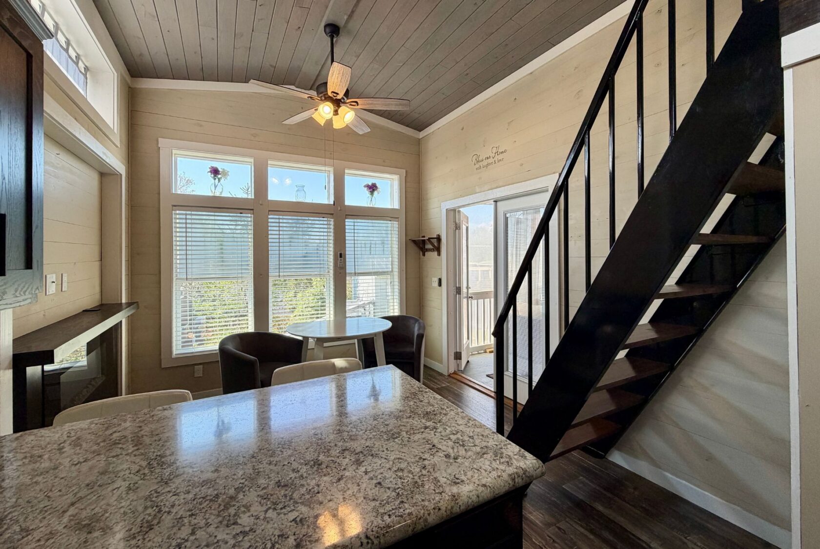 Cozy kitchen and dining area at 53 Highland Hill Lane features marble countertop, round table, and black metal staircase.