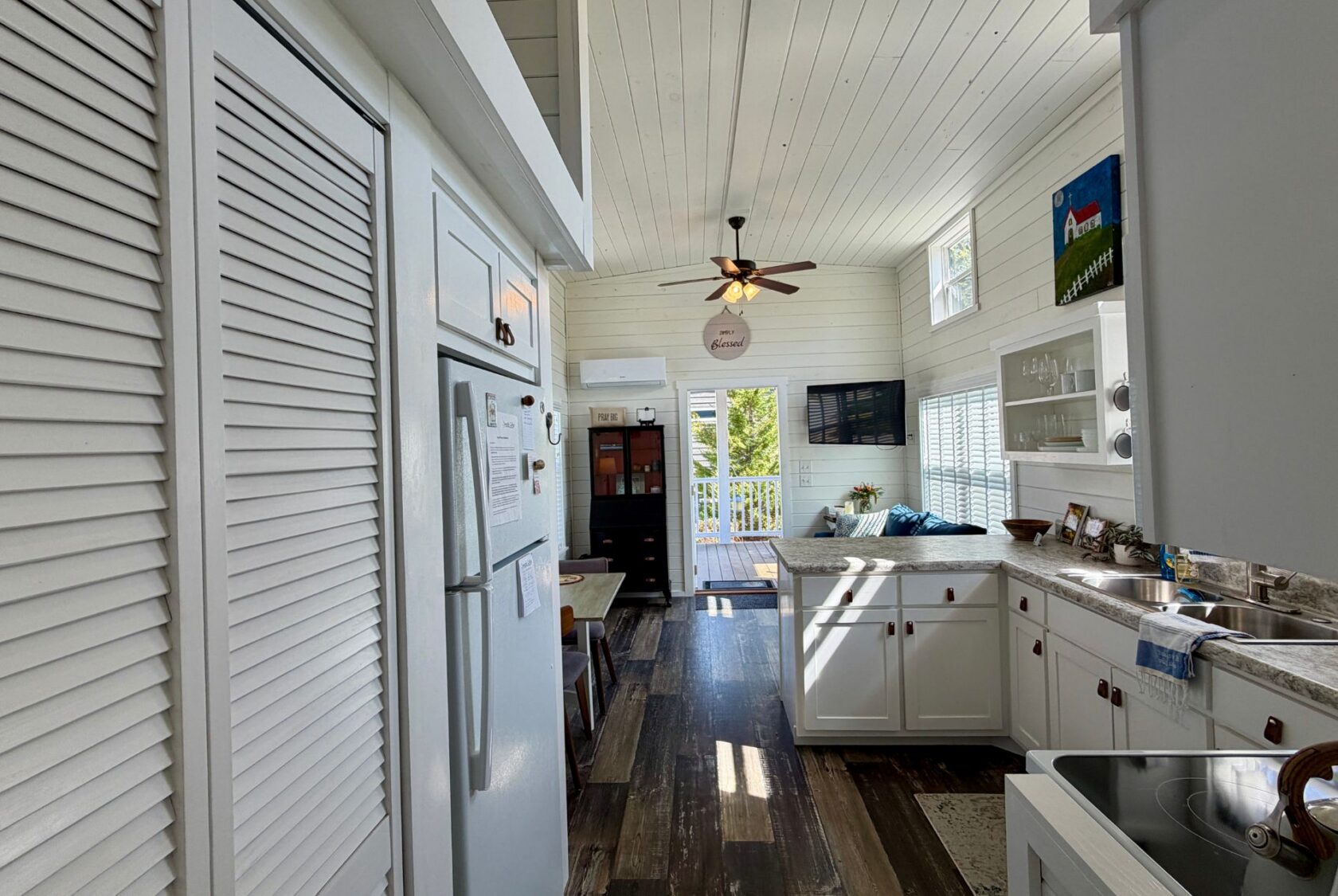 Bright, cozy kitchen at 47 Drifting Brook Lane with white cabinets, wood floors, and sunlight streaming through large windows.