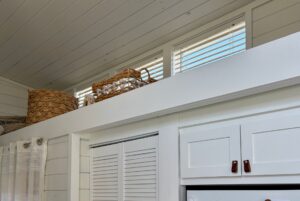 Wicker baskets on a high white shelf in the bright, modern real estate of 47 Drifting Brook Lane.