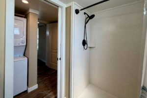 A bathroom at 53 Highland Hill with a shower right and stacked washer/dryer nook left—perfect real estate find.