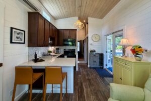 A cozy kitchen on Drifting Brook Lane with brown cabinets, bar seating, and bright natural light in a modern, wood-accented home.