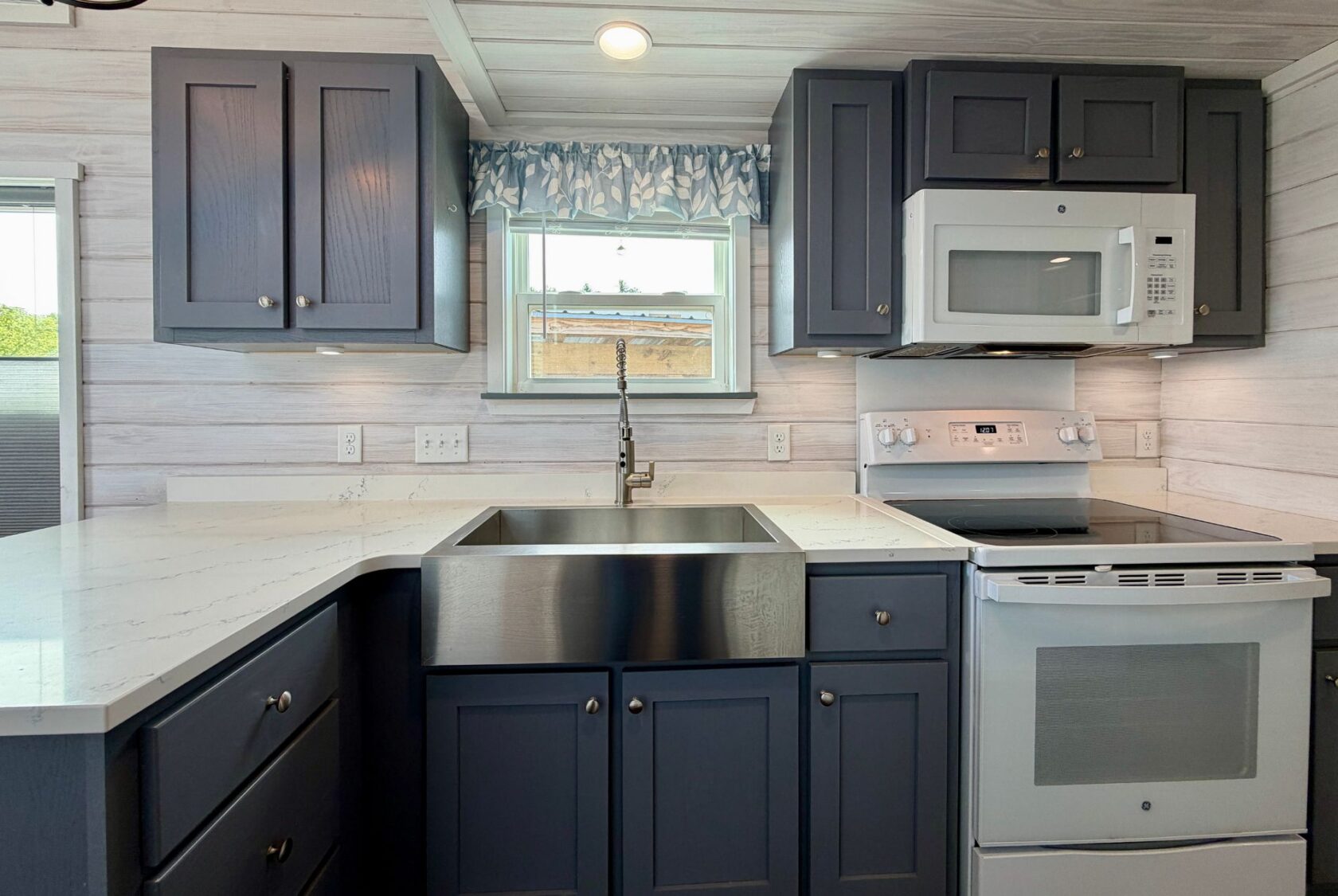 Modern kitchen with dark blue cabinets and white countertops, perfect for strolling Easy Lane in style.