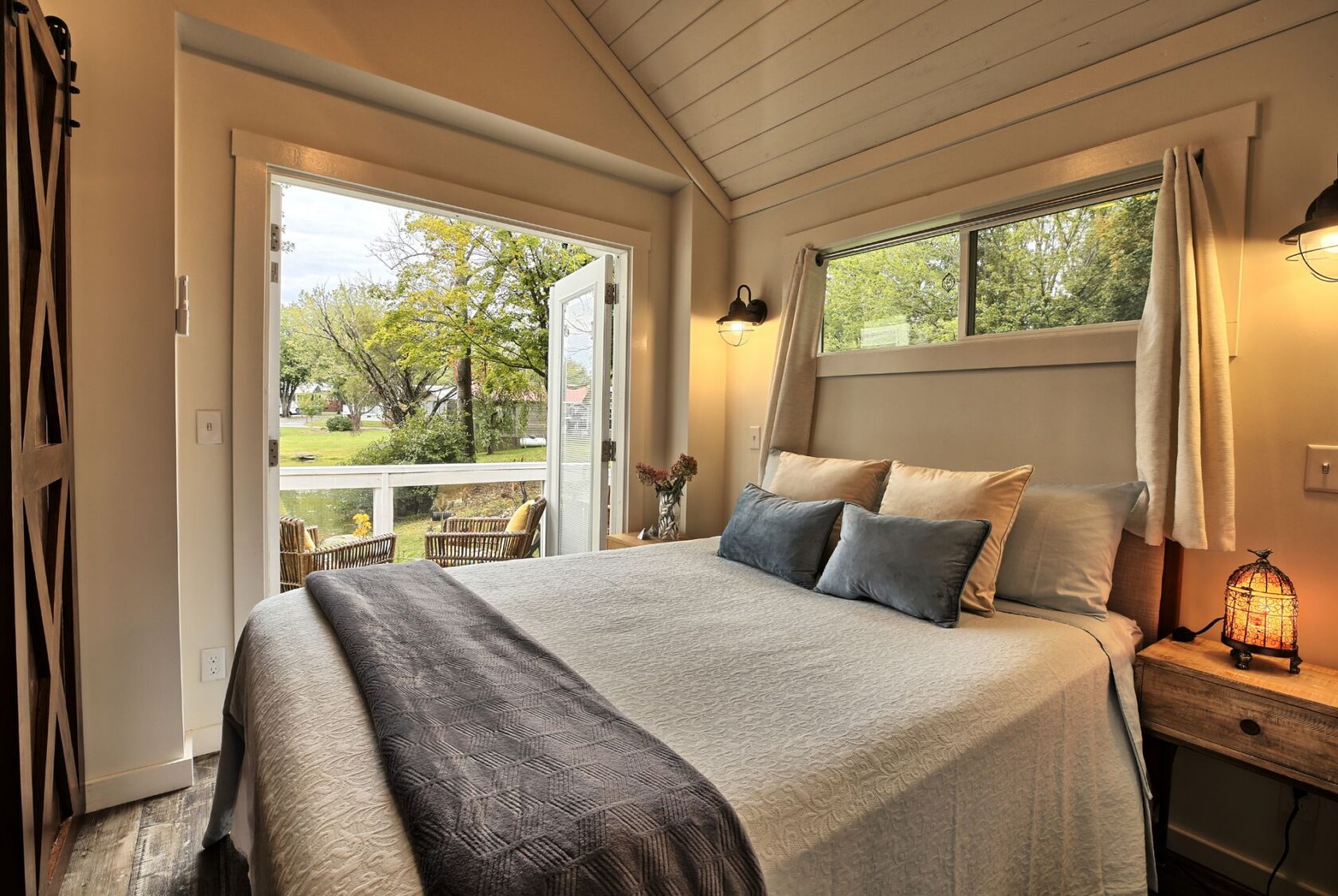 Cozy bedroom at 132 Drifting Brook with double doors and a view of the green yard—perfect for real estate seekers.