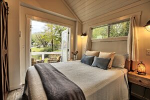 Cozy bedroom at 132 Drifting Brook with double doors and a view of the green yard—perfect for real estate seekers.