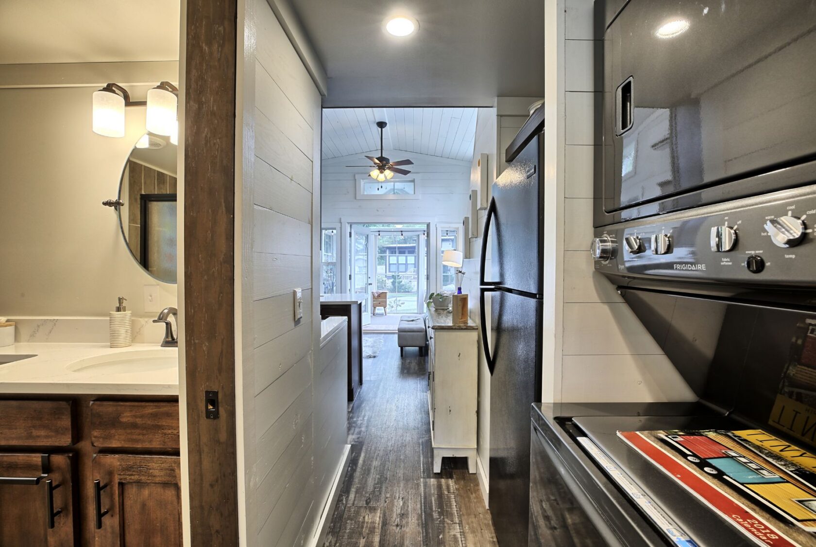 View of a narrow kitchen, bathroom on the left, leading to a bright living room at 132 Drifting Brook Lane real estate.