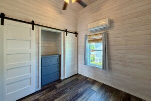 Small room with wood panel walls, sliding barn doors, and blue drawers—perfect for strolling down the Easy Lane.