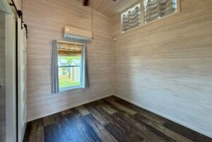 Empty room with wood-paneled walls, dark floor, and mini split AC—perfect for Strolling Easy Lane living.