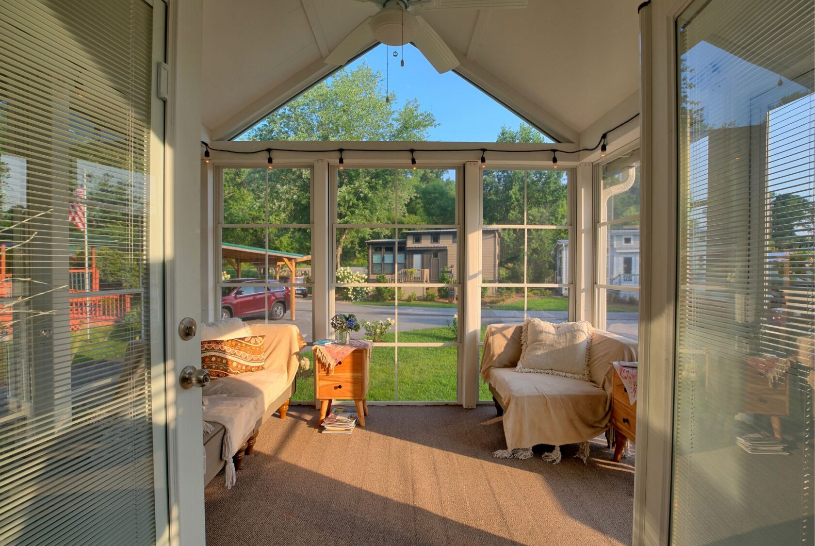 A sunroom with large windows, cozy chairs, and yard views at 132 Drifting Brook in a peaceful neighborhood.