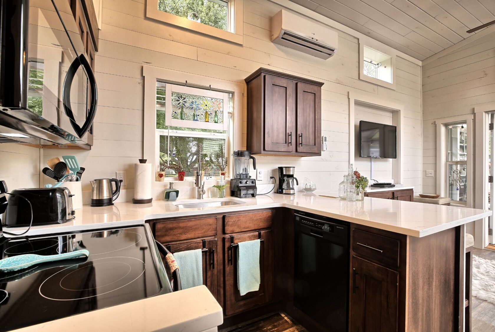 Bright, modern kitchen at 132 Drifting Brook Lane with dark wood cabinets, white countertops, and large windows.