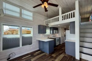 Modern tiny house interior with loft, kitchen, and wooden floors evokes the calm of Strolling Easy Lane.