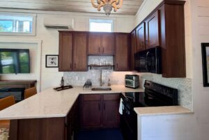 Modern kitchen at 59 Drifting Brook with dark wood cabinets, white countertops, and stainless steel appliances.