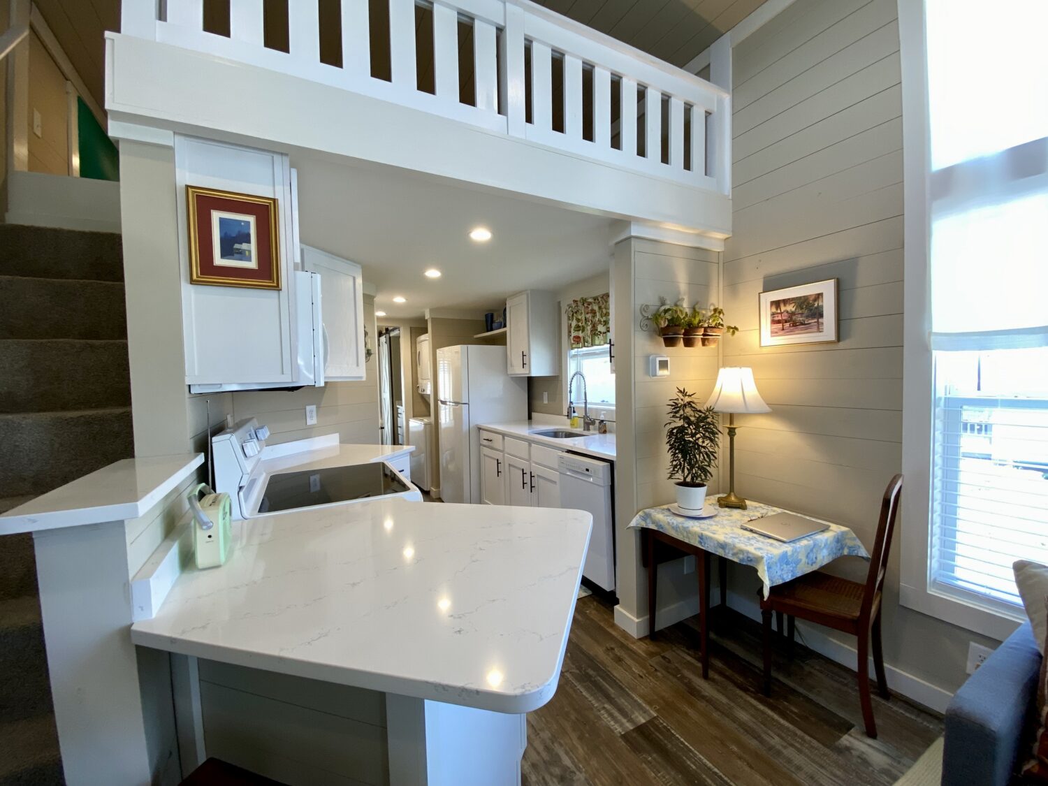 Bright, cozy kitchen on Skipping Stone Lane with white cabinets, marble counter, and a small dining area by the window.
