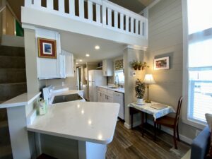 Bright, cozy kitchen on Skipping Stone Lane with white cabinets, marble counter, and a small dining area by the window.