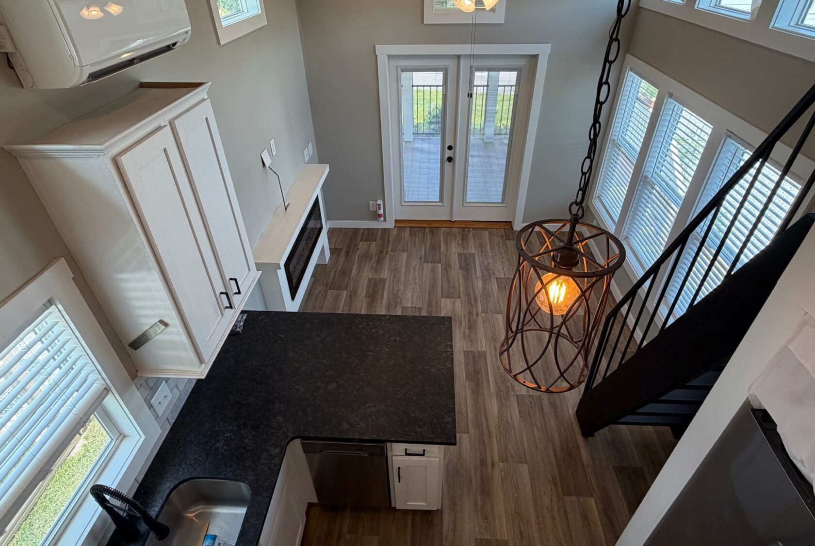 View of a modern kitchen and living area at 103 Meandering Lane, with wood floors, large windows, and stylish lighting.