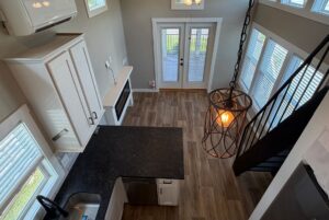 View of a modern kitchen and living area at 103 Meandering Lane, with wood floors, large windows, and stylish lighting.