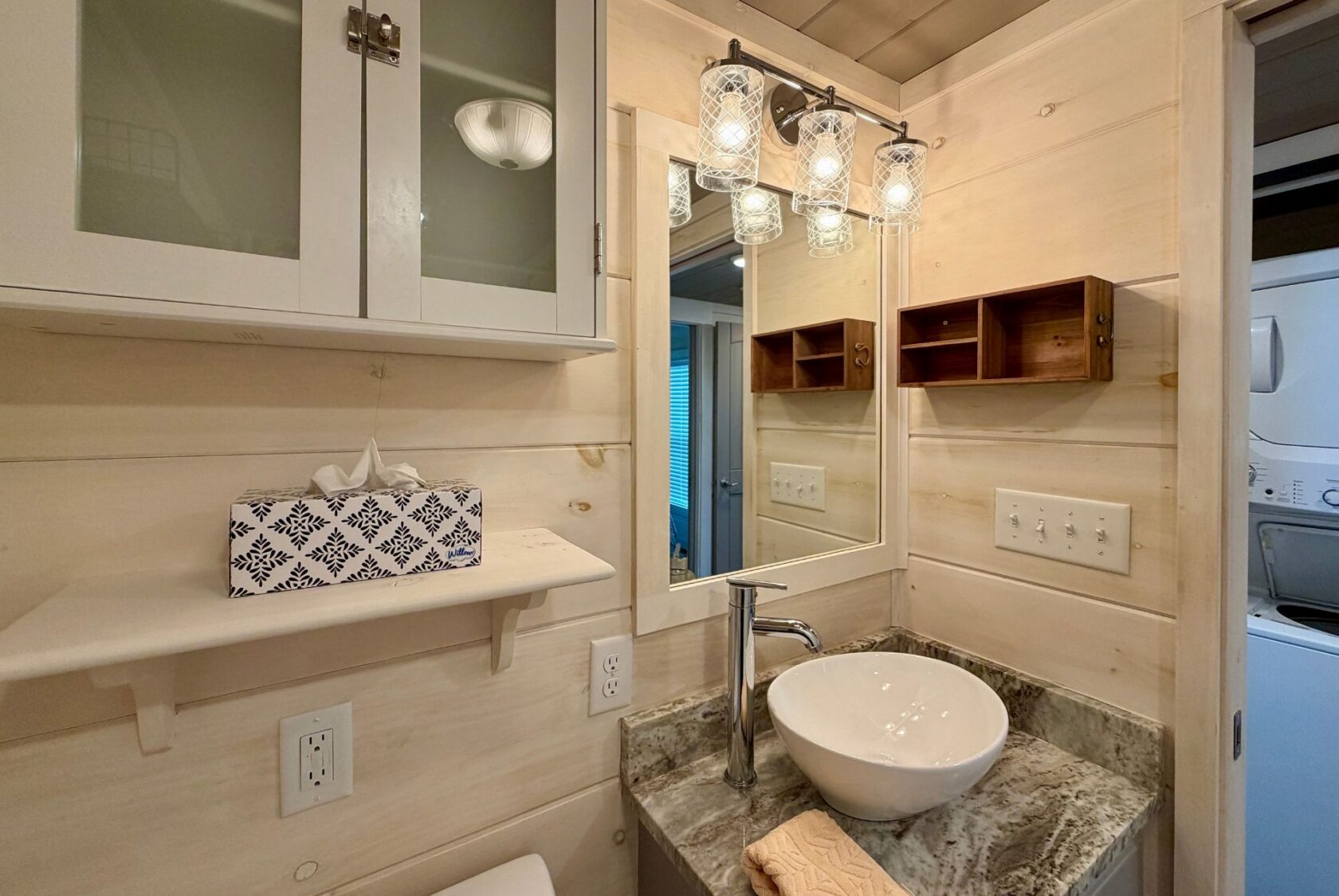 Modern Highland Hill Lane bathroom with vessel sink, granite counter, wall shelves, and a lighted mirror.