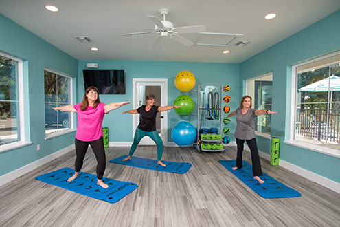 women in fitness studio stretching
